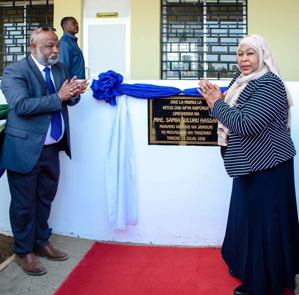 President Samia Suluhu Hassan unveils a plaque, accompanied by a man in a suit